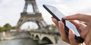 Woman in Paris using her cell phone in front of Eiffel Tower